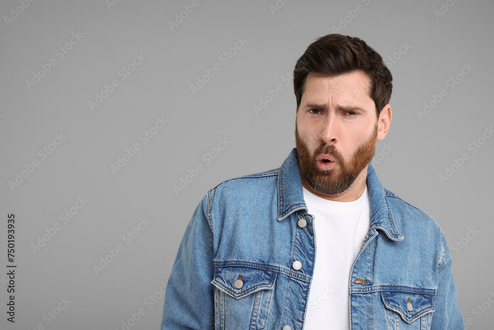 Portrait of surprised man on grey background, space for text Portrait of surprised man on grey background, space for text