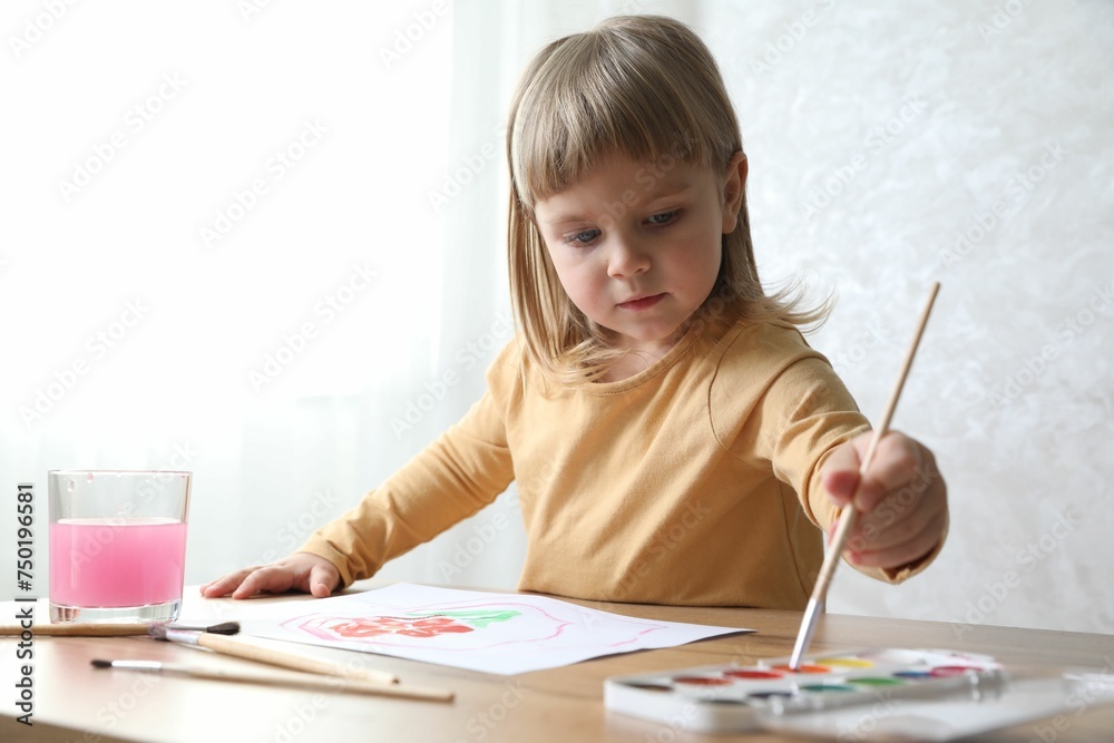 Cute little girl drawing with brush at wooden table indoors. Child`s art Cute little girl drawing with brush at wooden table indoors. Child`s art