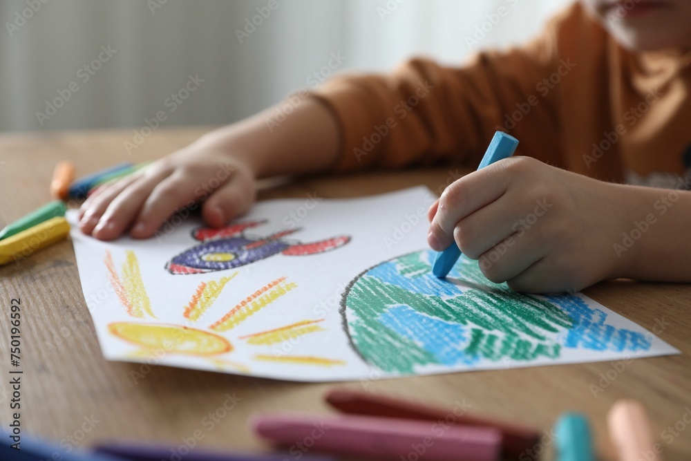 Little girl drawing picture with soft pastel at wooden table indoors, closeup. Child`s art Little girl drawing picture with soft pastel at wooden table indoors, closeup. Child`s art