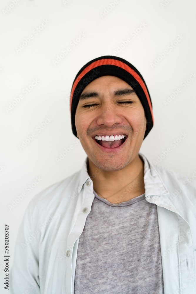 Latin man wearing a beanie on the white background smiling Latin man wearing a beanie on the white background smiling