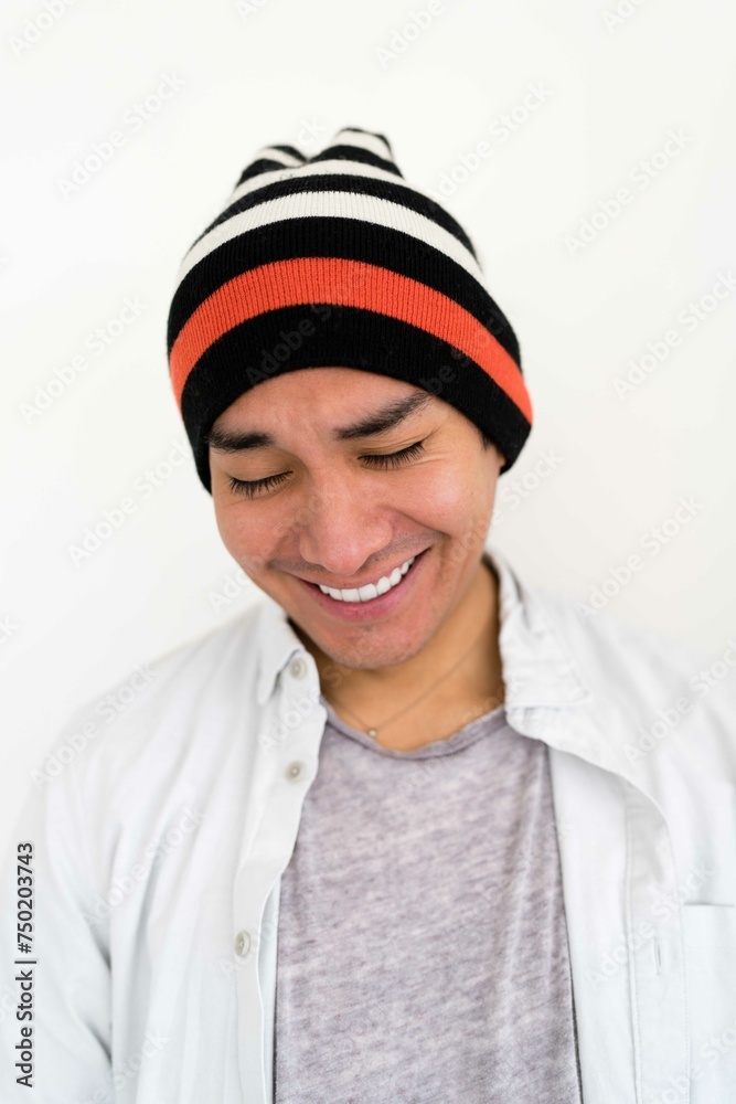 Latin man wearing a beanie on the white background smiling Latin man wearing a beanie on the white background smiling