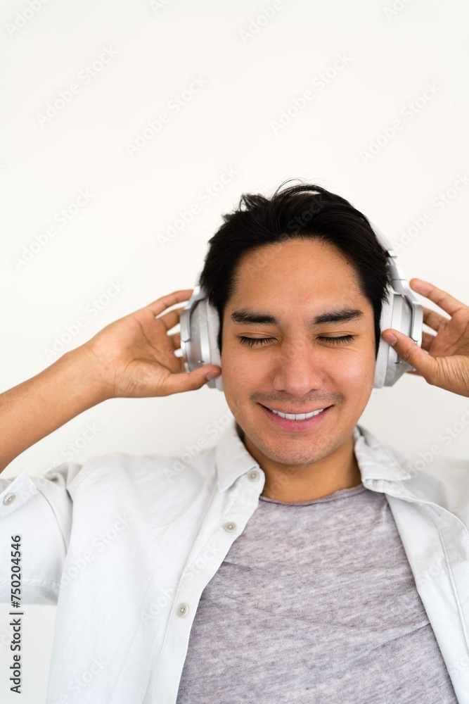 Latin man wearing headphones on the white background Latin man wearing headphones on the white background