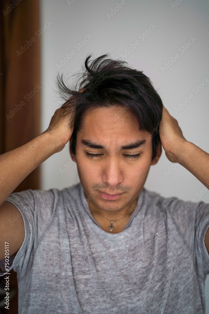 Sleepy Latin man touching his hair Sleepy Latin man touching his hair