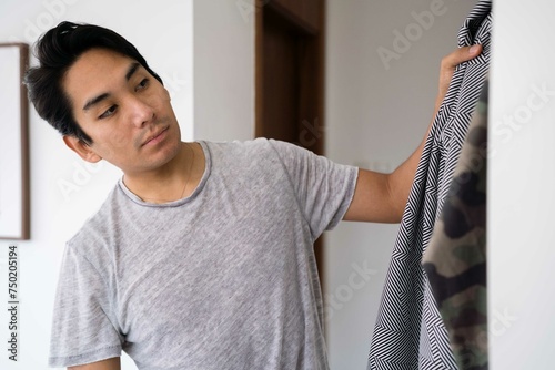 Latin man choosing clothing from his wardrobe