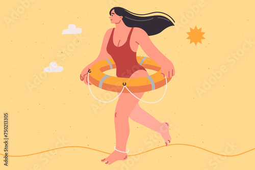 Woman beach lifeguard dressed in swimsuit walks along seashore with lifebuoy on belt