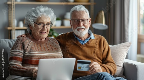  happy senior couple doing online shopping on the internet laptop at home.
