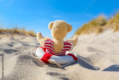 Seaside Dune Summer Pleasure / Little teddy bear with swimsuit and nostalgic life buoy have fun at beach sand (copy space)