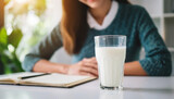 Blurred woman's hand on table with milk, depicting lactose intolerance