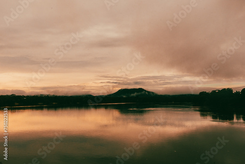 Sunset over the Vaupes River in the Amazon jungle next to a hill.