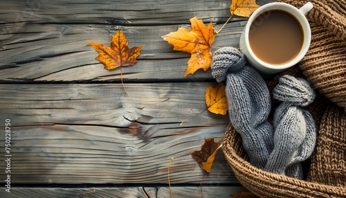 Autumn themed wooden background with coffee leaves and cozy knitted accessories photo