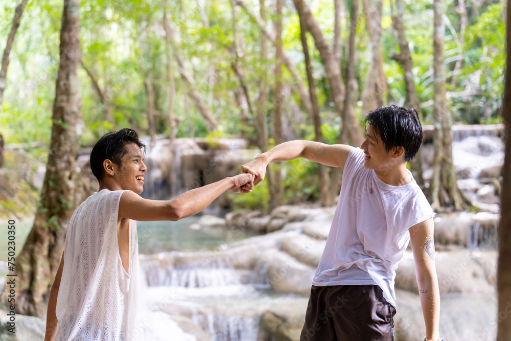 Two Asian man friends enjoy and fun outdoor lifestyle travel forest mountain on summer holiday vacation. Happy generation z people friends holding hands together during travel nature at waterfall. Two Asian man friends enjoy and fun outdoor lifestyle travel forest mountain on summer holiday vacation. Happy generation z people friends holding hands together during travel nature at waterfall.