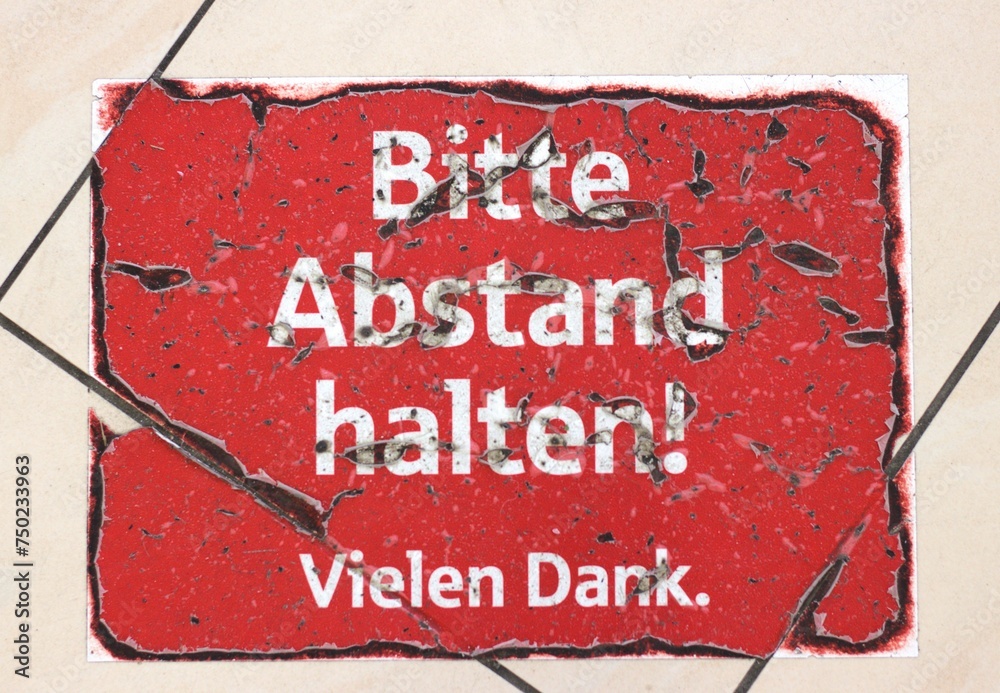 Dank Sign Foto de Worn-out red sign on tiled floor in German: Bitte Abstand ...