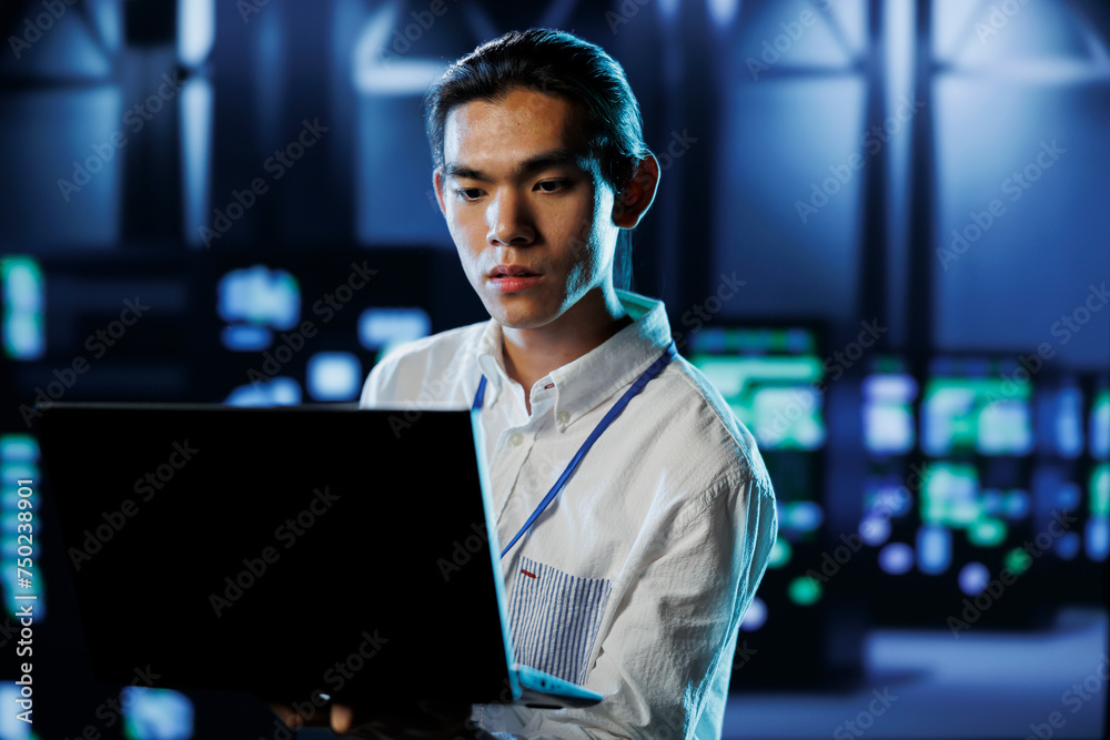 Fototapeta premium Qualified engineer between server hub rows providing processing resources for businesses worldwide. Certified expert fixing data center mainframes tasked with managing massive databases