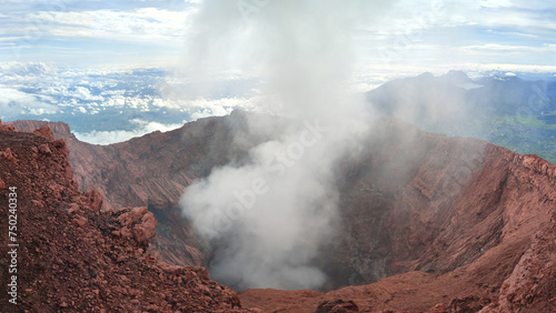 Smoke from inside the crater of an active volcano in Mount Kerinci with large caldera in Indonesia