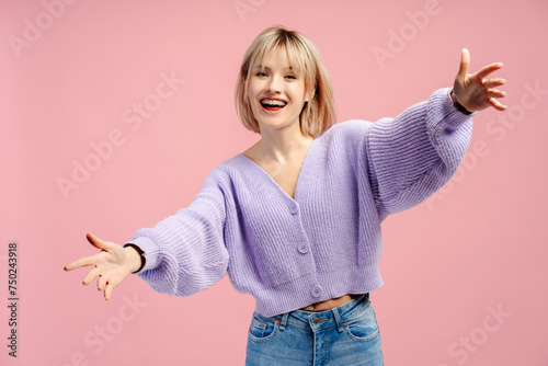 Portrait of happy beautiful young woman with braces wearing casual outfit hugging looking at camera photo