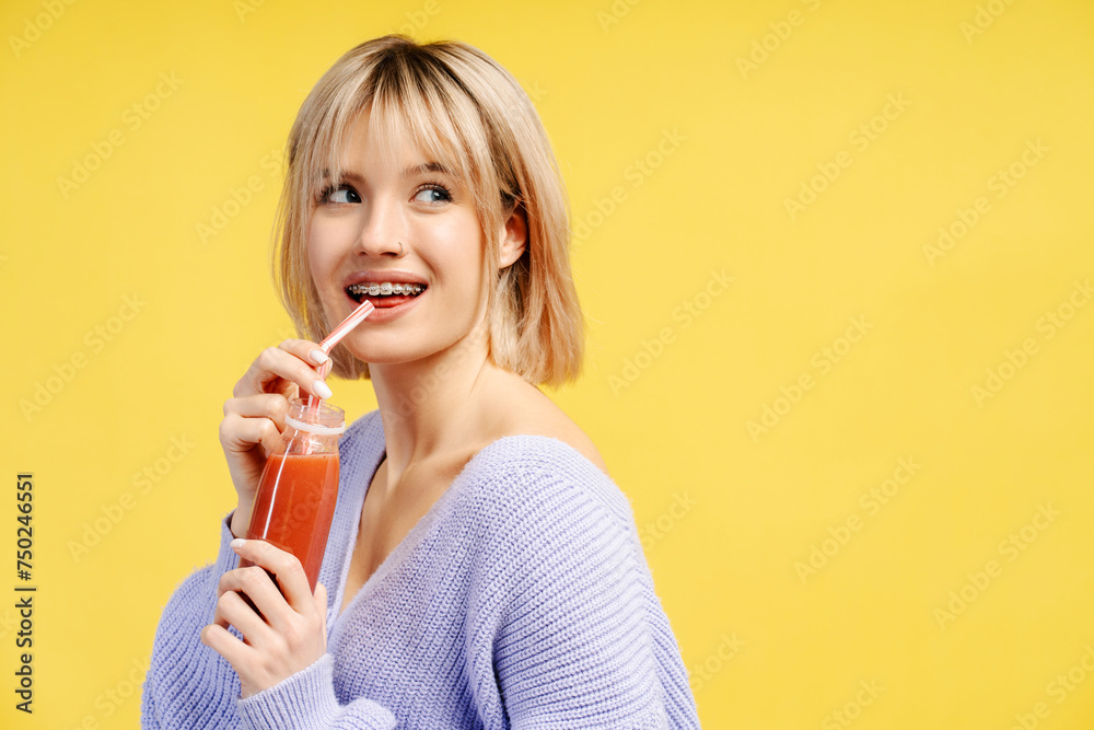 Portrait of happy young Caucasian woman holding bottle with juice or smoothie drinking, looking away Portrait of happy young Caucasian woman holding bottle with juice or smoothie drinking, looking away