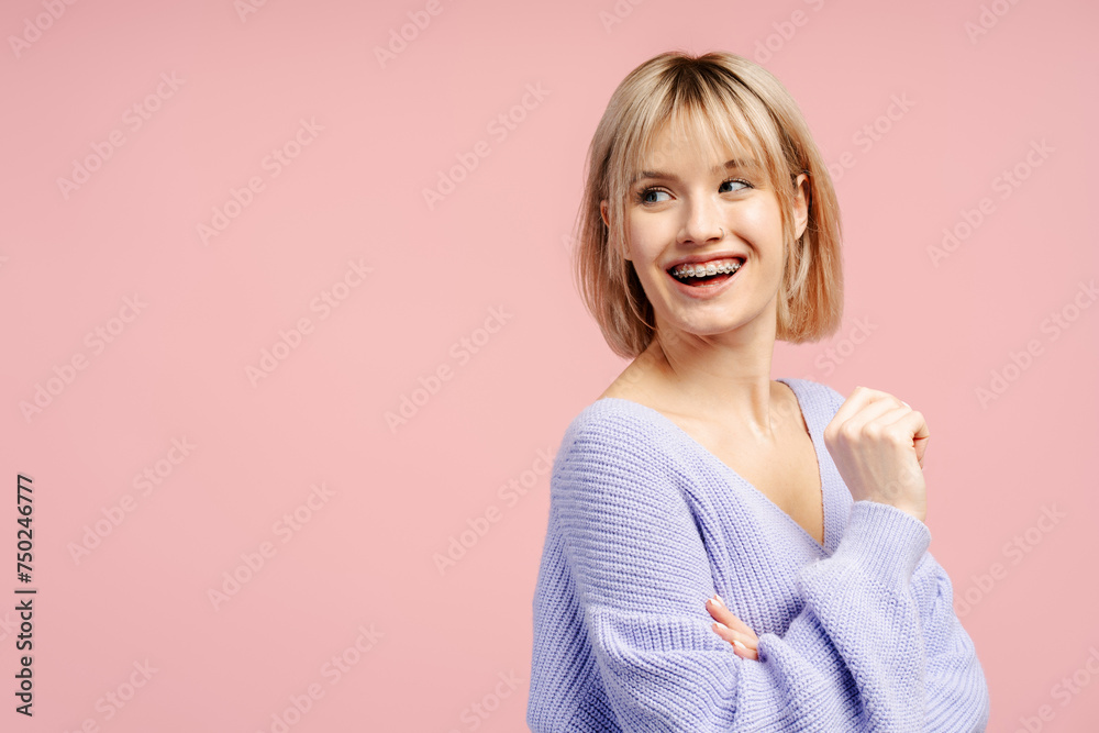 Smiling young beautiful woman with braces and blonde hair looking away. Confident female student