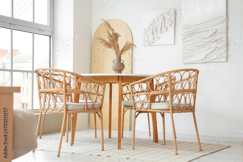 Interior of light room with dining table and 3D paintings