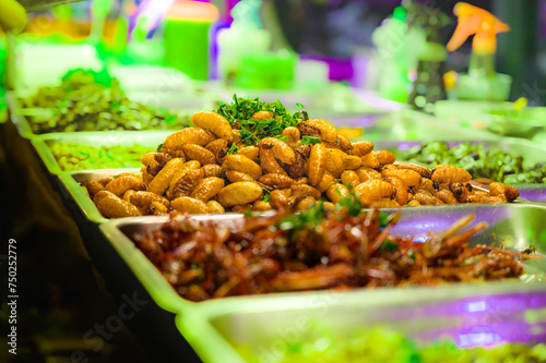 Fried red palm weevil with salt and pepper on a food stall photo