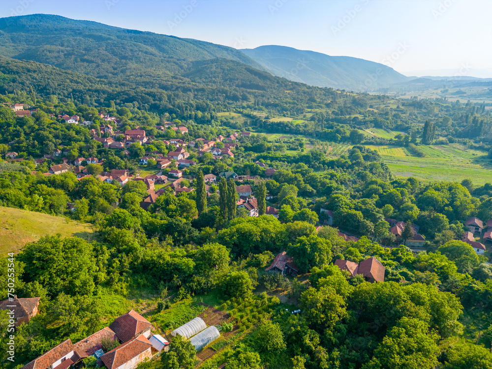 Aerial landscape of the mountains and houses with green fields and scenery in village.