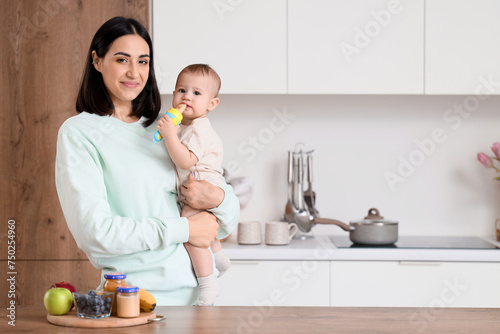 Mother giving her little ba...