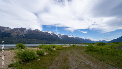 Dirt road winding through New Zealand mountains. A rugged path meanders through wild landscapes with snow-capped peaks in the distance. Concept of Adventure, Exploration, Wilderness, Scenic, Journey