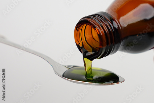 Pouring cough syrup into spoon concept background