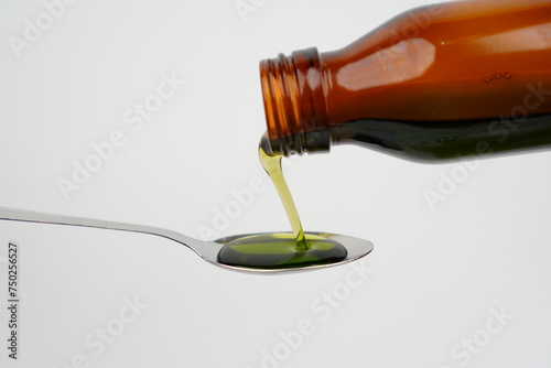 Photos Liquid medicine pouring from a bottle on a spoon concept background