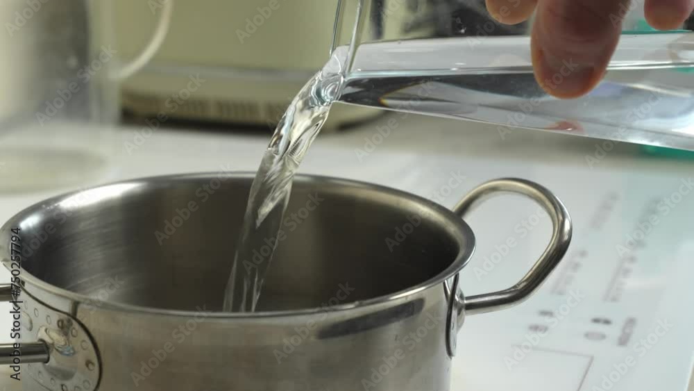 A pot fills with water on an electric stove. Captivating cooking moment, perfect for culinary content. A pot fills with water on an electric stove. Captivating cooking moment, perfect for culinary content.