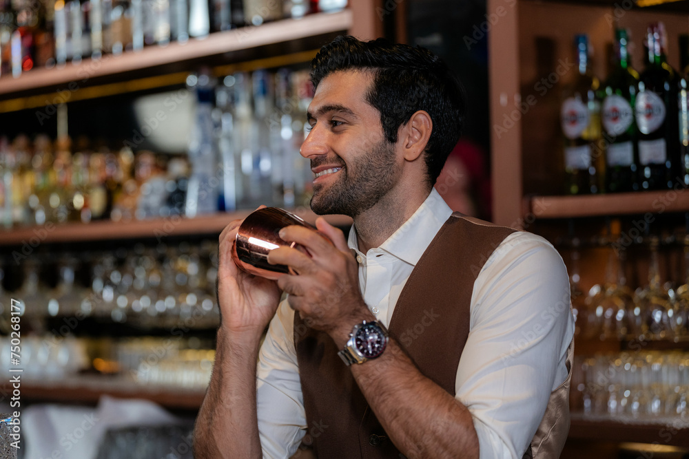 Man bartender is making a drink and dancing at bar. Dance party with group people dancing . Women and men have fun and drinking martini cocktail in night club. Man bartender is making a drink and dancing at bar. Dance party with group people dancing . Women and men have fun and drinking martini cocktail in night club.