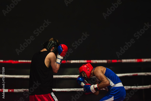 combat of two boxers over black background. Copy space