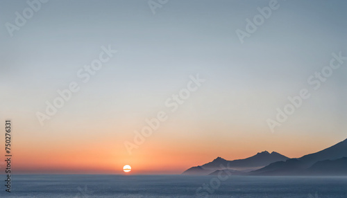 sunset over the ocean with mountains in the background