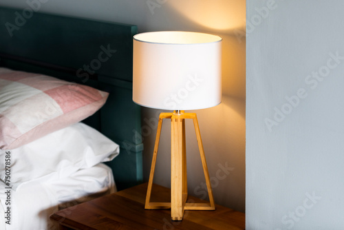 Modern Lamp on Bedside Table and a Cozy Set of Pillows on the Bed