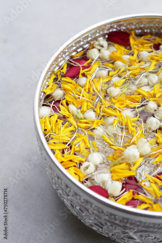 Water with jasmine flower  marigold petals and rose petals in silver bowl. Thai tradition  Songkran festival concept