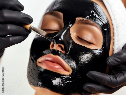 Woman Receiving a Detoxifying Charcoal Facial Mask, Serene Spa Beauty Treatment