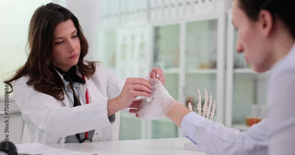 Doctor bandages upper limb of patient arm Doctor bandages upper limb of patient arm