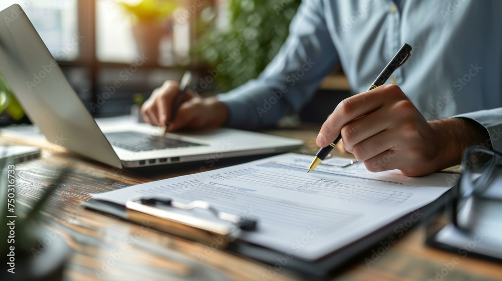 A man is writing on a piece of paper with a pen A man is writing on a piece of paper with a pen