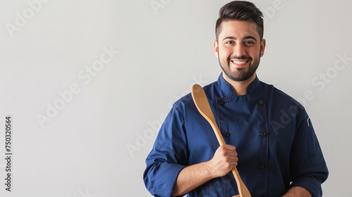 A white background with a blank expression on the face of a guy chef wearing a blue outfit and holding a wooden spoon