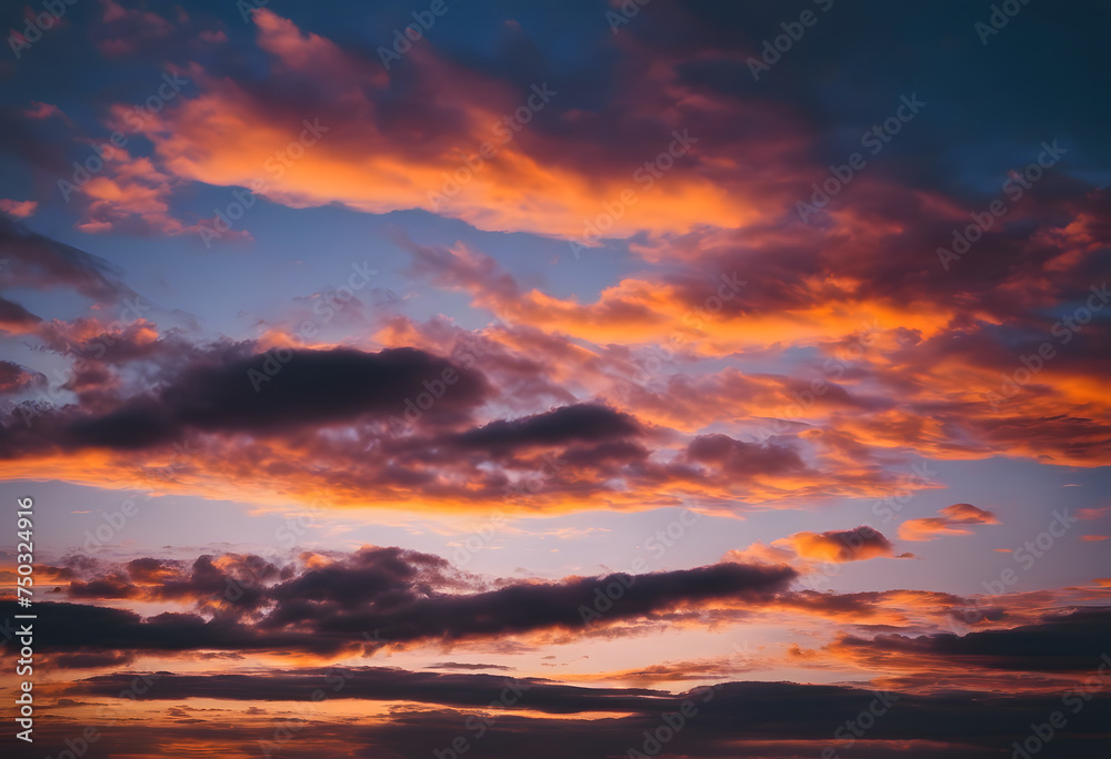 Dramatic sunset sky with fiery orange clouds and deep blue hues, ideal for backgrounds or nature themes.