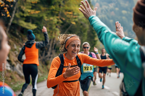 Happy marathon runners giving high-five to each other during the race in nature