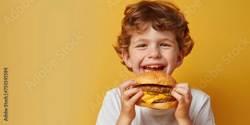 portrait of a kid eating delicious hamburger on color background  copy space