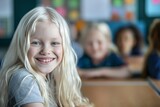 white albino girl with long hair smiling, sitting in a school classroom at a desk, blur background with other children. Albinism Awareness day. Neurodiversity. 13 june