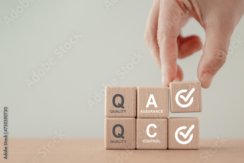QA and QC quality assurance and quality control text and correct sign on wood cube blocks, for Business and industry, analysis, quality, guarantee, process, check, approve, customer and satisfaction