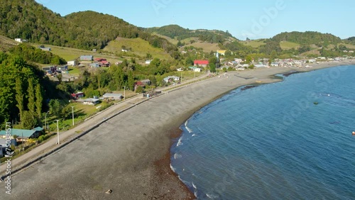 Aerial shot of Tenaun beach in Chiloé with lush green hills and a curving shoreline photo