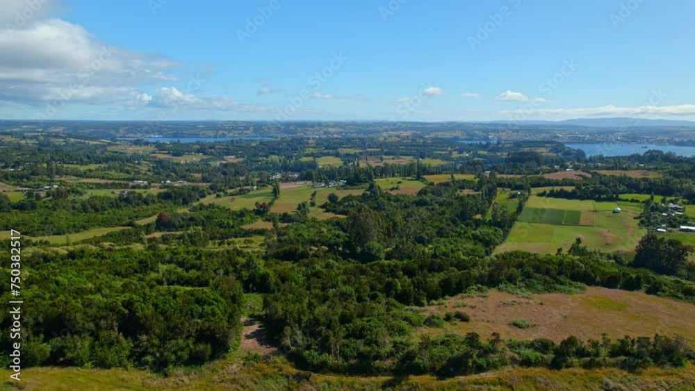 Lemuy island's vibrant landscape with lush fields and distant ocean, aerial view Lemuy island's vibrant landscape with lush fields and distant ocean, aerial view