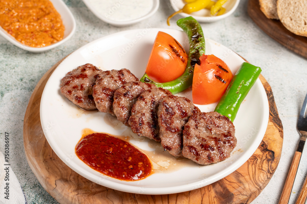 Grilled meat balls. With Tomatoes, Peppers, Appetizers and Special Sauce. Turkish meatballs on a plate Grilled meat balls. With Tomatoes, Peppers, Appetizers and Special Sauce. Turkish meatballs on a plate