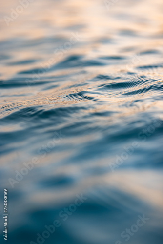 Beautiful closeup sea water surface. Sunset sunrise gold blue colors calm soft waves relaxing horizon. Dream fantasy shallow focus, blur seascape sky. Tranquil peaceful nature pattern, Mediterranean
