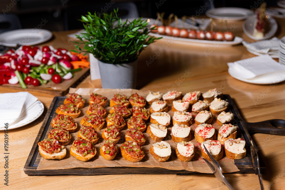 Assorted Bruschetta Platter on Wooden Board. An appetizing selection of bruschetta with various toppings on a rustic wooden board, ready for event catering.