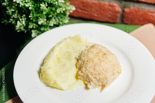 Chicken Breast Cutlet with Mashed Potatoes on Plate. A simple yet appetizing meal of a juicy chicken breast cutlet served alongside creamy mashed potatoes on a white plate.