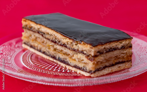cake with nuts and marmalade, in layers, on a red background, Greta Garbo photo